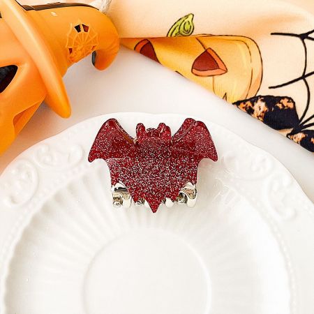 Close-up of a red glitter bat wing hair clip.
