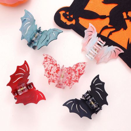 A collection of bat-shaped hair clips in various colors including black, red, and gradient.