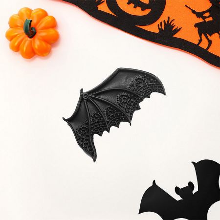 Bat wing hair clips styled as part of a larger Halloween decoration set with a pumpkin and banner.