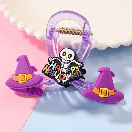 A purple Halloween claw clip decorated with a witch hat and a 'Happy Halloween' message.