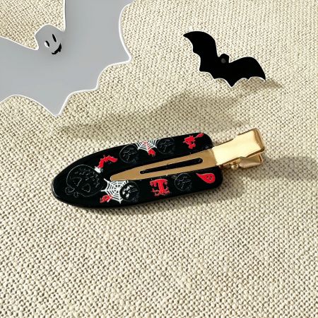 A close-up view of the gold-tone metal clasp on a Halloween-themed acrylic hair clip.