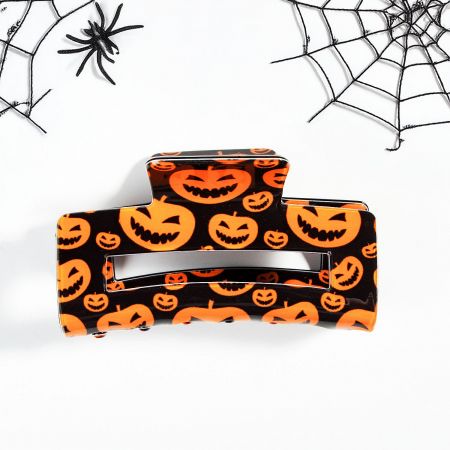 A bright orange jack-o'-lantern claw clip, adding a festive touch to any look.
