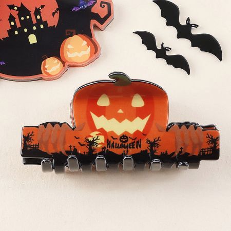 A vibrant orange jack-o'-lantern hair clip for Halloween.