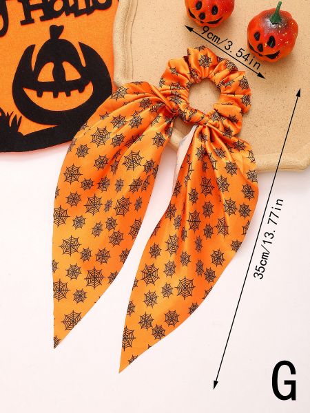 An orange Halloween scrunchie with a black spider web pattern and long ribbon tails.