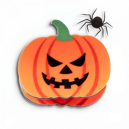 Close-up of a pumpkin hair clip showing its detailed jack-o'-lantern face.