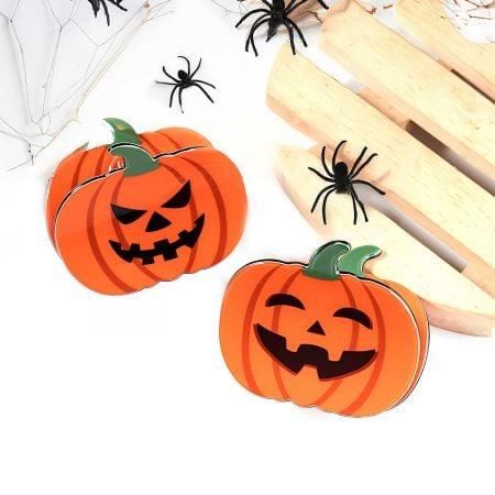 A pumpkin hair clip shown with a decorative spider, perfect for a complete Halloween look.