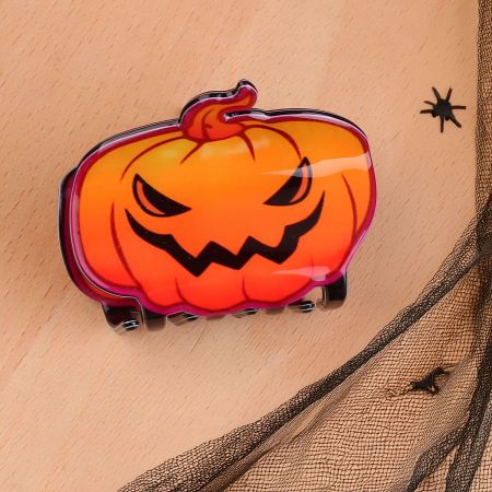 A vibrant orange pumpkin hair clip, perfect for festive hairstyles.