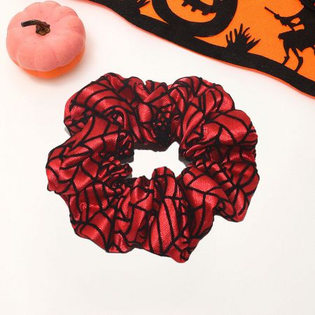 A red Halloween scrunchie with a black spider web pattern.