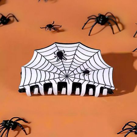 Close-up of a white spider web hair claw with decorative plastic spiders.