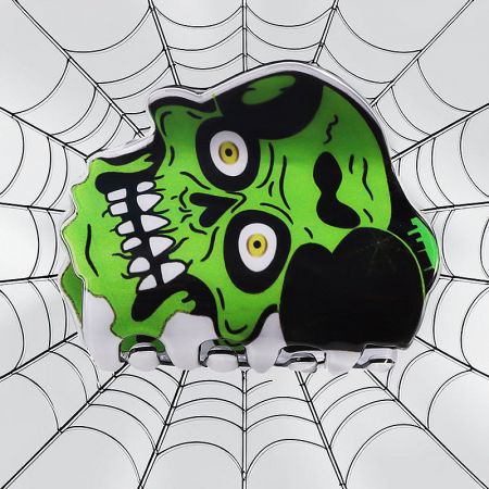 Close-up of a green zombie head Halloween hair claw clip.