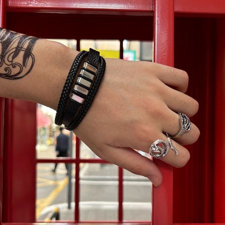 The Skull Ring for Men worn on a hand, featured in a stylish urban setting with a red telephone booth background.