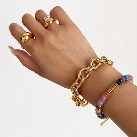 A styled lifestyle shot of a hand adorned with the complete set of five gold-tone bracelets, demonstrating a stacked look.