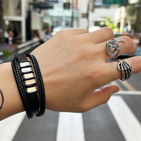 A model wearing the Skull Ring for Men alongside other silver and black jewelry pieces to showcase styling options.
