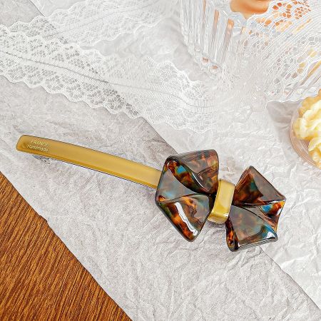 Close-up of a handmade tortoiseshell acetate bow hair clip from France.