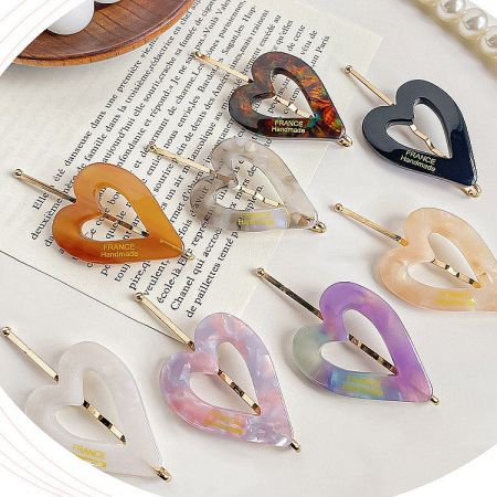 Close-up of handmade heart-shaped hair clips from France in various colors and patterns.