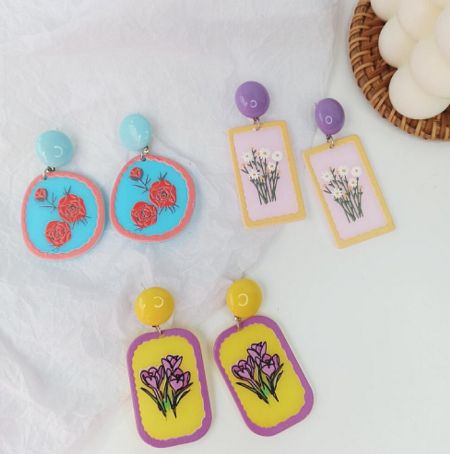 Three pairs of handmade polymer clay earrings showcasing intricate floral designs.