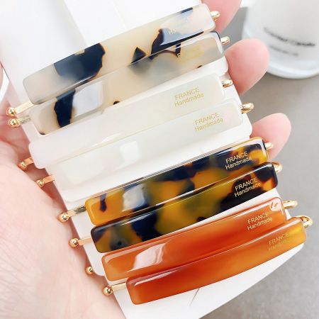 Close-up of handmade tortoiseshell acetate hair clips with elegant gold accents.