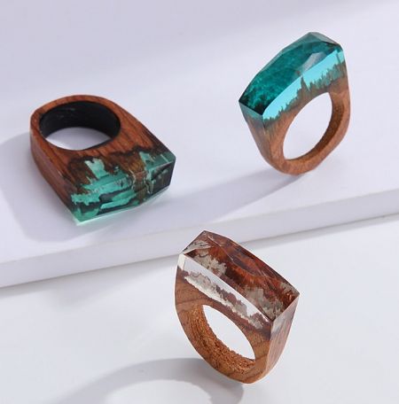 Unique handmade wooden rings with colorful resin inlays, highlighting the craftsmanship in the collection.