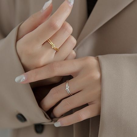 A model wearing the gold plated knot ring alongside a silver ring to showcase its versatile style.