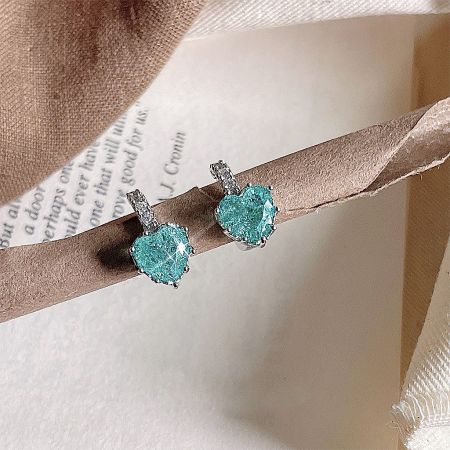 Silver Plated Green Glass Heart Shape Drop Huggie Earrings (5 Pairs) - A close-up of a silver-plated huggie earring featuring a dangling heart-shaped green glass charm, showcasing its delicate design and vibrant color.