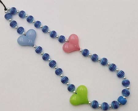 A close-up view of the heart-shaped and striped beads on the phone charm strap.