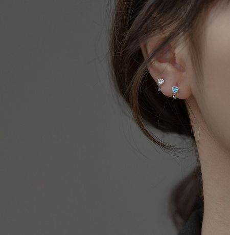 Close-up view of the sterling silver hoop earring with a brilliant blue cubic zirconia stone.