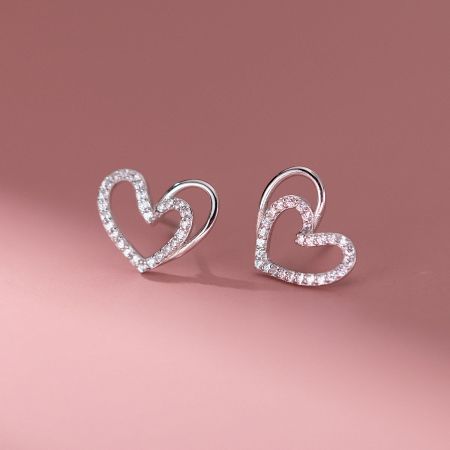 A pair of silver heart-shaped stud earrings encrusted with small cubic zirconia stones.