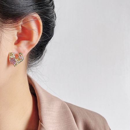 Detailed view of the irregular heart design with pink and clear gemstones.