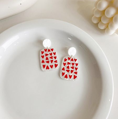 A pair of charming heart-shaped acrylic earrings, perfect for a playful summer look.