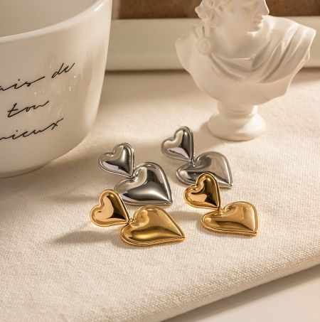 Stainless Steel Double Heart Drop Earrings - A pair of stainless steel double heart drop earrings, one in a polished gold finish and the other in a sleek silver finish, displayed side-by-side.