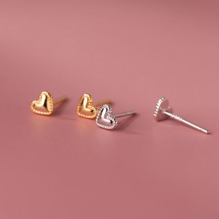 A pair of heart-shaped earrings in both gold and silver finishes displayed side-by-side.
