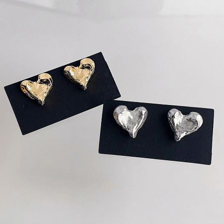 Two pairs of heart-shaped earrings, one gold and one silver, showcasing their unique irregular shape.