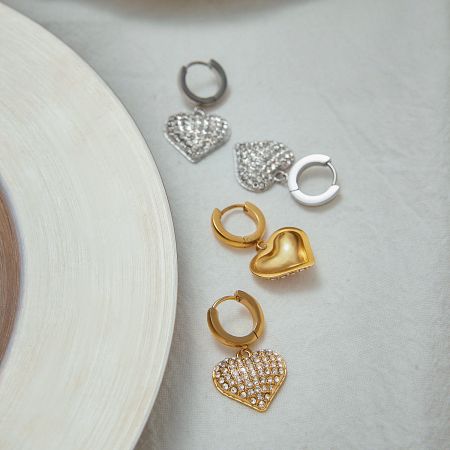 A close-up view of the PVD gold plated Heart Zircon Hoop Earrings, styled with other stainless steel jewelry pieces.