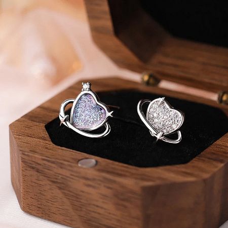 A close-up of the glittery heart earrings in a wooden presentation box.