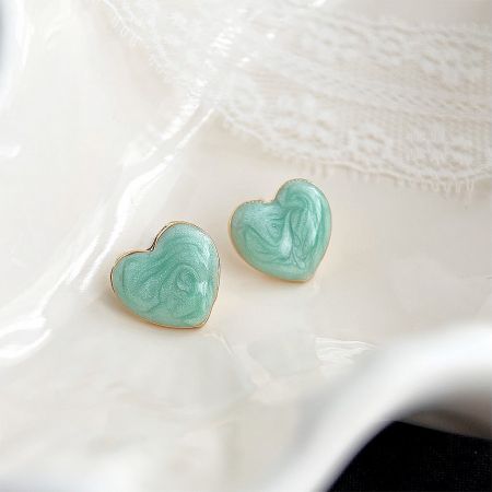 Heart-shaped earrings with a teal marbled design and gold trim.