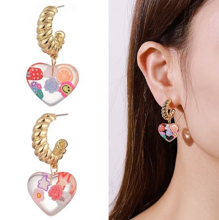 A pair of charming heart-shaped acrylic earrings with embedded floral and sweet treat patterns, complete with gold-tone posts.