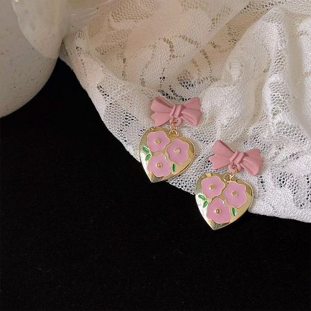 Another angle of the gold-colored heart earrings with pink flowers and bows.