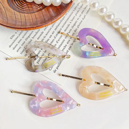 A pair of pastel-colored heart-shaped hair clips with 'FRANCE Handmade' label.