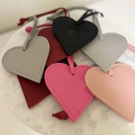 Multiple heart-shaped leather tags in various colors, showcasing customization options.