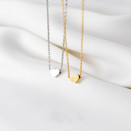 Silver and gold heart necklaces shown side-by-side.