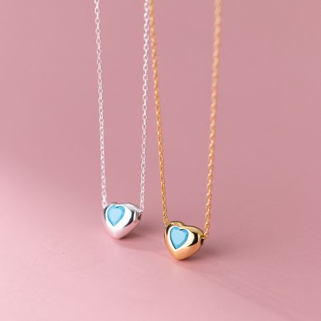 Silver and gold heart necklaces with elegant blue inlays, crafted from 925 sterling silver.