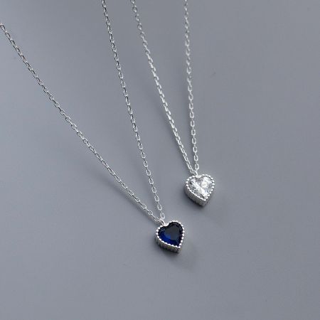 Detailed view of the blue and clear zircon heart pendants on silver chains.