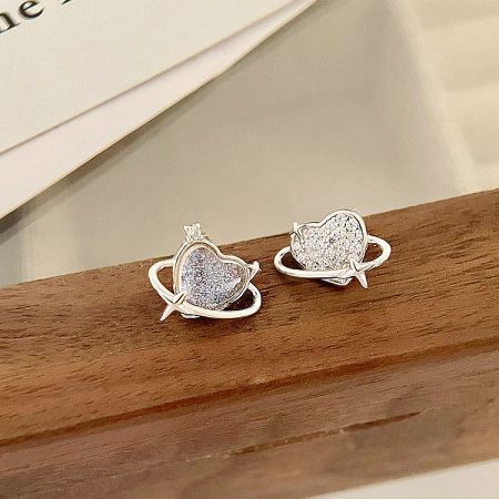 The pair of heart and planet earrings displayed together.