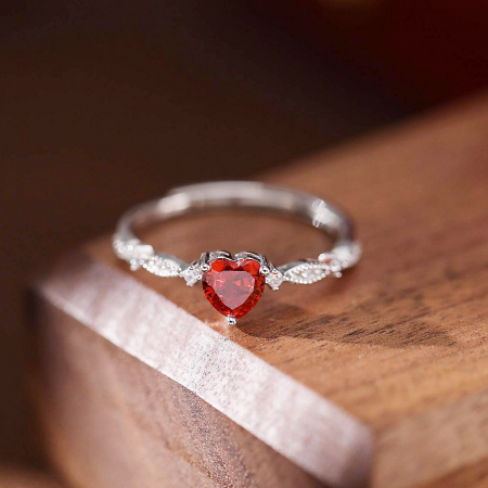 Side profile of the silver heart-shaped ruby ring, showcasing the band's texture.