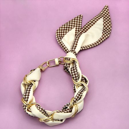 Classic houndstooth pattern silk scarf phone strap with gold chain details.
