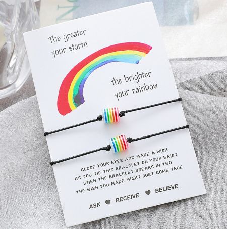 Side view of the handmade rainbow bead bracelet on an inspirational 'Make a Wish' card.