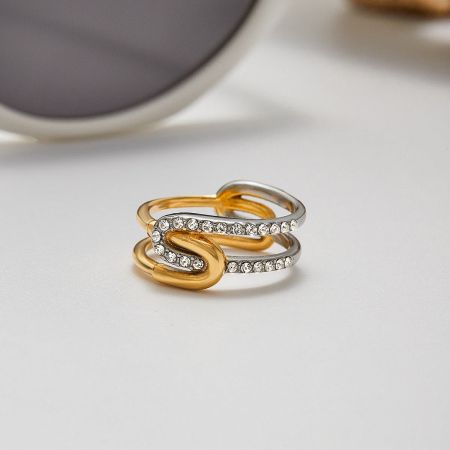A pair of intertwined two-tone rings from the set, showing the gold and silver bands with rhinestone details.