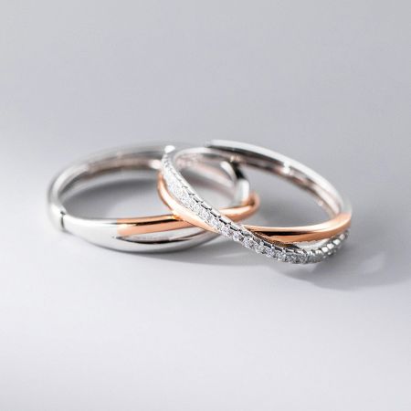 A product shot of three intertwined Möbius rings, highlighting the combination of precious metals and diamond-like stones.