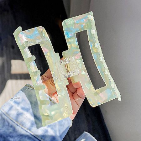 Close-up of iridescent rectangular hair clips, highlighting their unique finish.