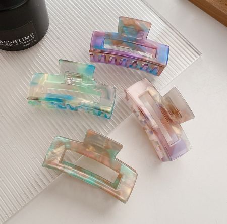 Wholesale Acetate Hair Clips - A collection of four wholesale acetate hair clips in vibrant, multicolored iridescent finishes, showcasing various color combinations.